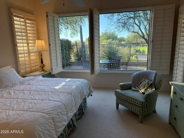a bedroom with a bed chair and a large window