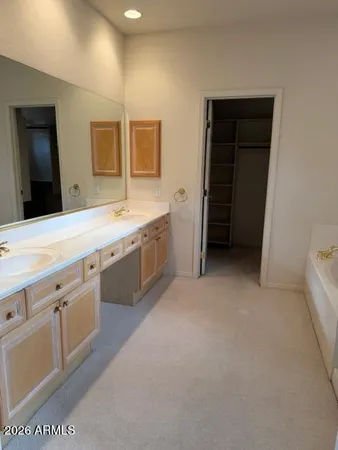 a spacious bathroom with a double vanity sink and a mirror