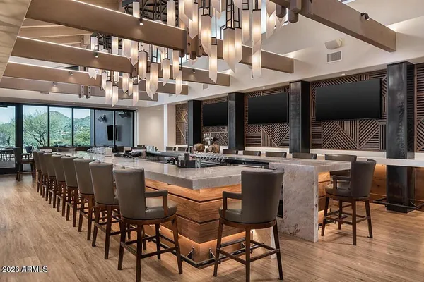 a kitchen with lots of counter and chairs