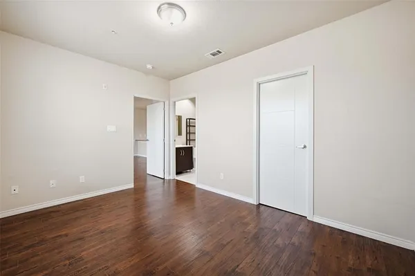 a view of an empty room with wooden floor