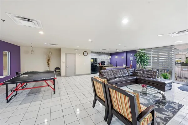a living room with furniture a flat screen tv and a table