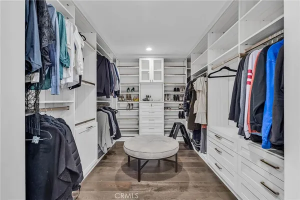 a view of walk in closet with wooden floor