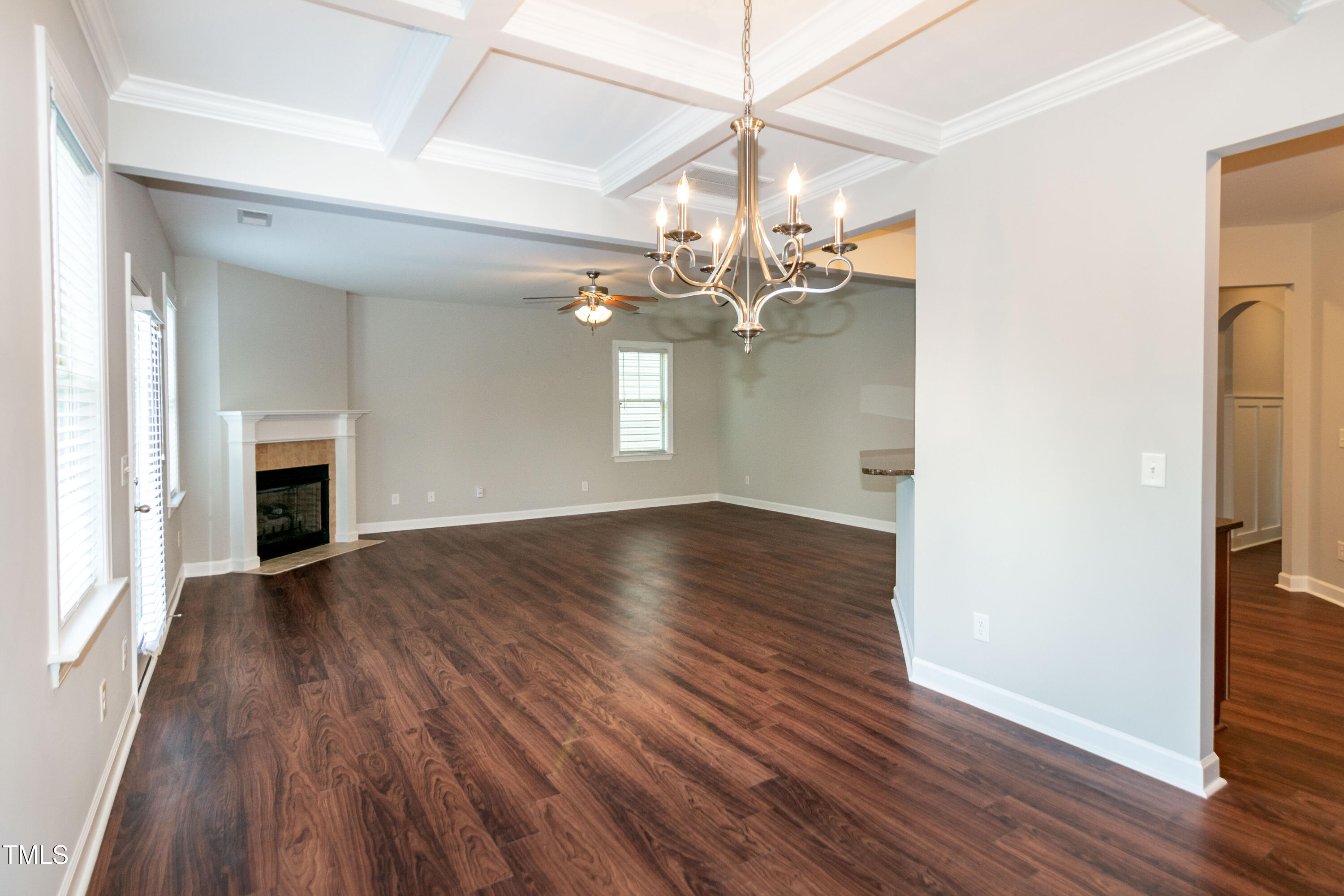 206 Roundhouse Lane Morrisville, NC 27560 - Photo 15 of 42 an empty room with wooden floor chandelier and fireplace