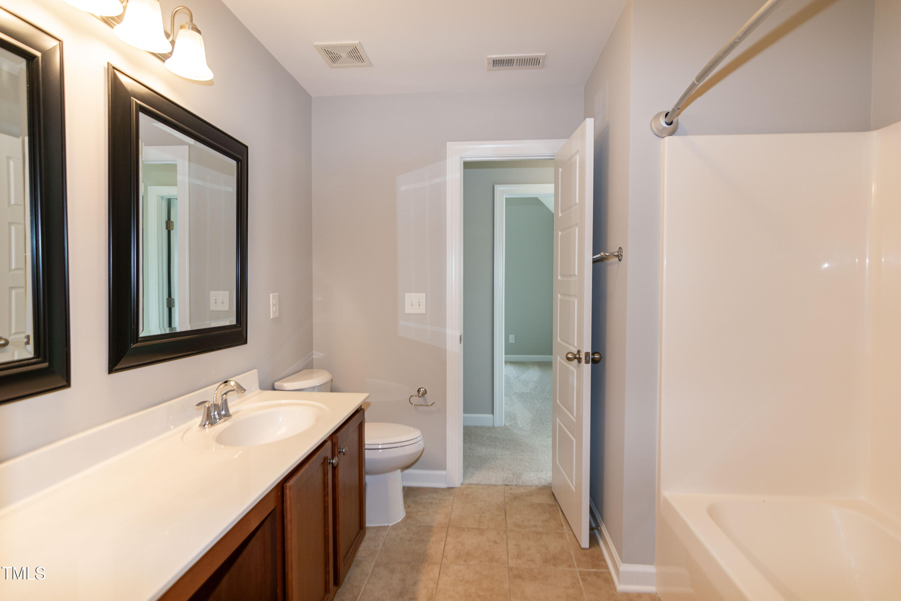 206 Roundhouse Lane Morrisville, NC 27560 - Photo 30 of 42 a bathroom with a double vanity sink toilet mirror and bathtub
