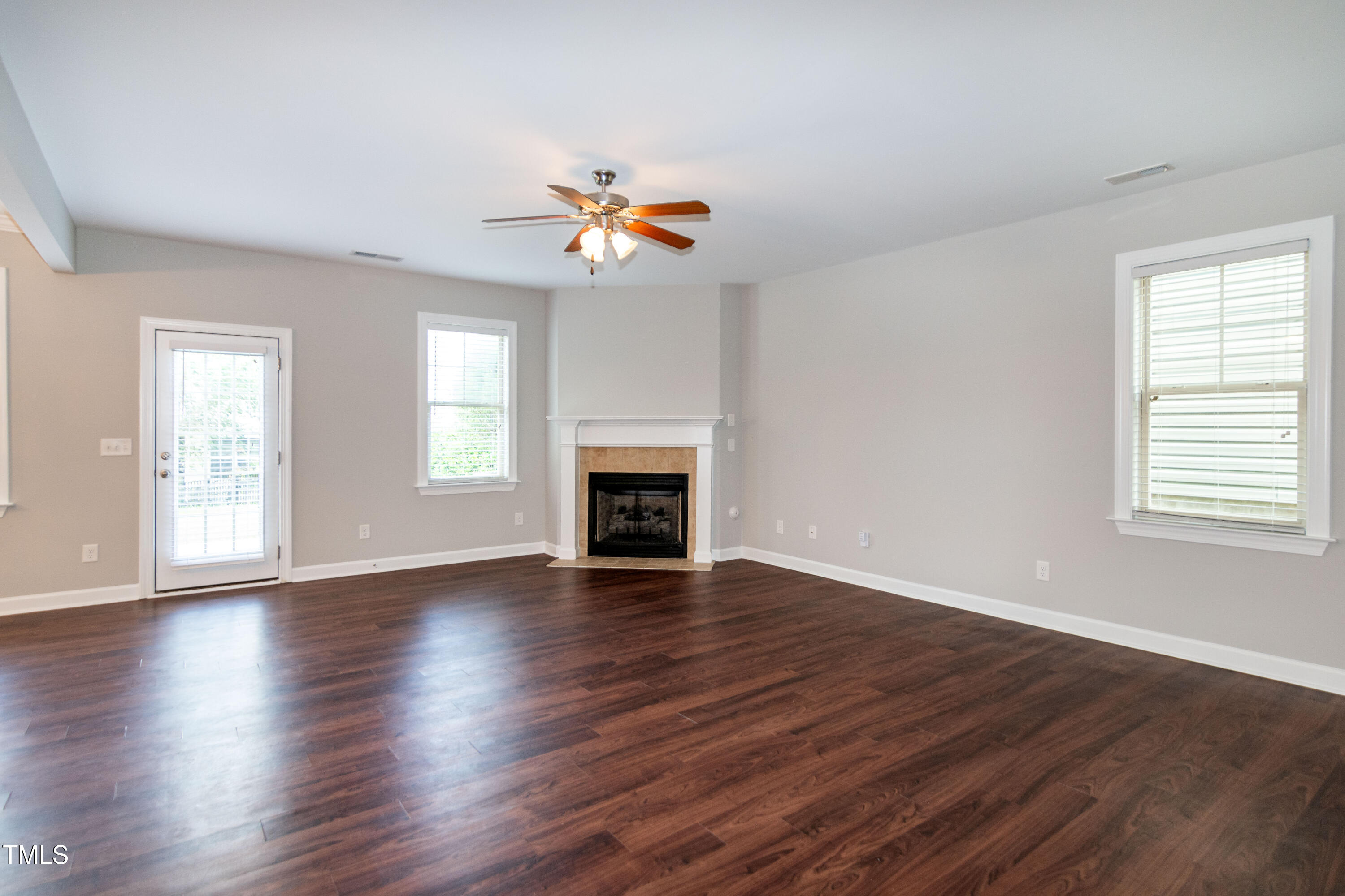 206 Roundhouse Lane Morrisville, NC 27560 - Photo 6 of 42 an empty room with wooden floor fireplace and windows