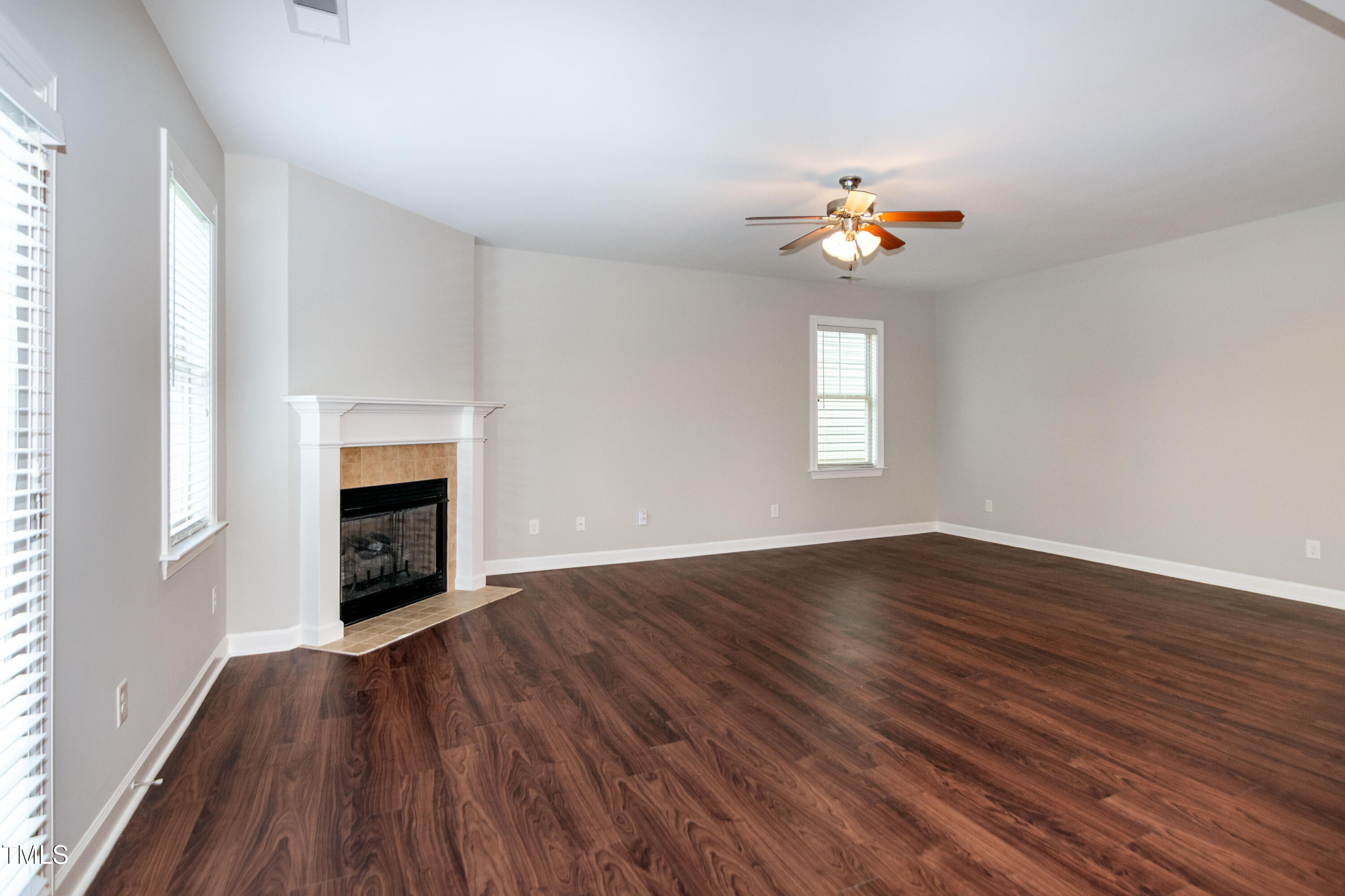 206 Roundhouse Lane Morrisville, NC 27560 - Photo 8 of 42 an empty room with wooden floor fireplace and fan