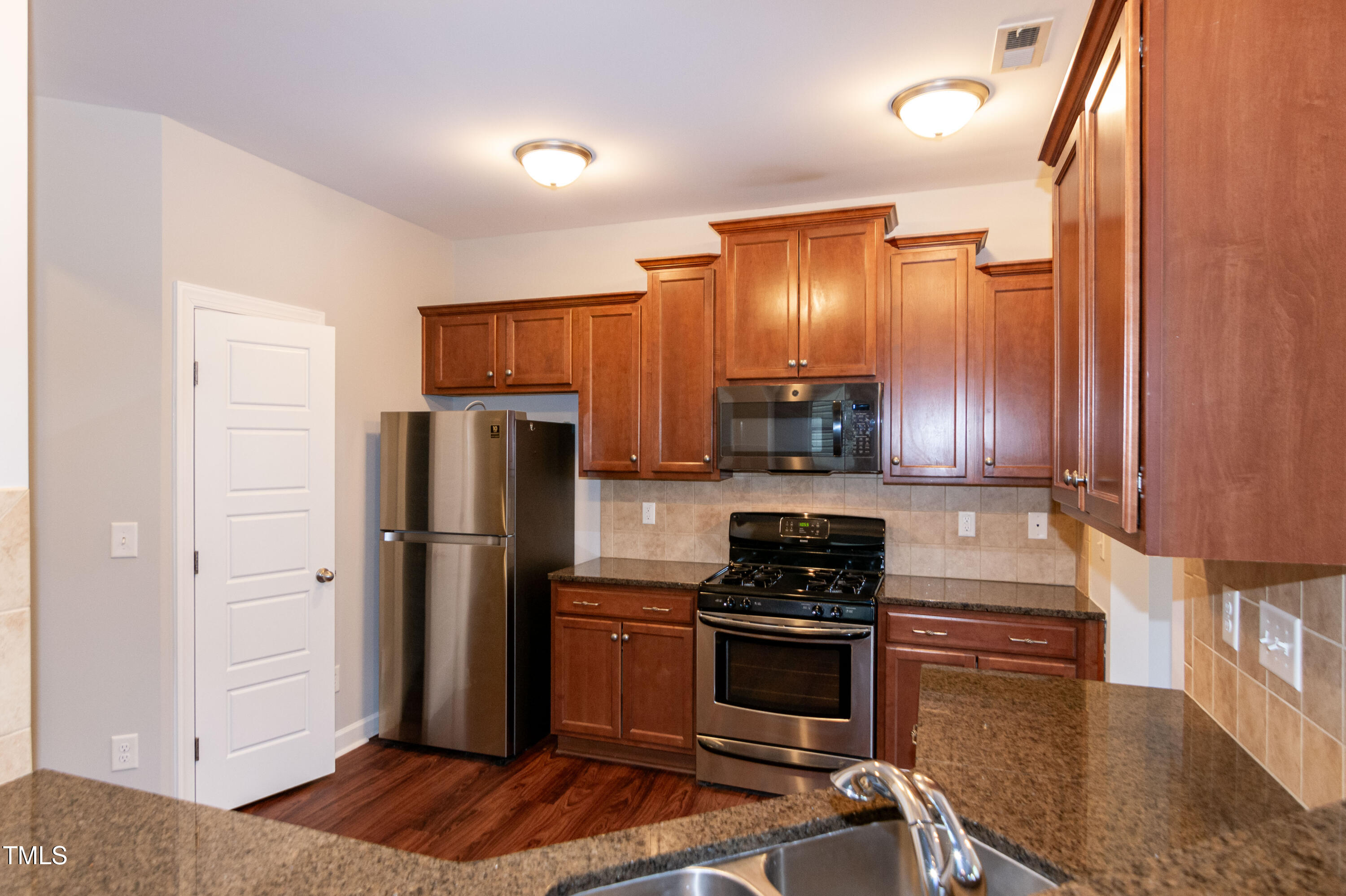 206 Roundhouse Lane Morrisville, NC 27560 - Photo 9 of 42 a kitchen with a refrigerator stove and cabinets