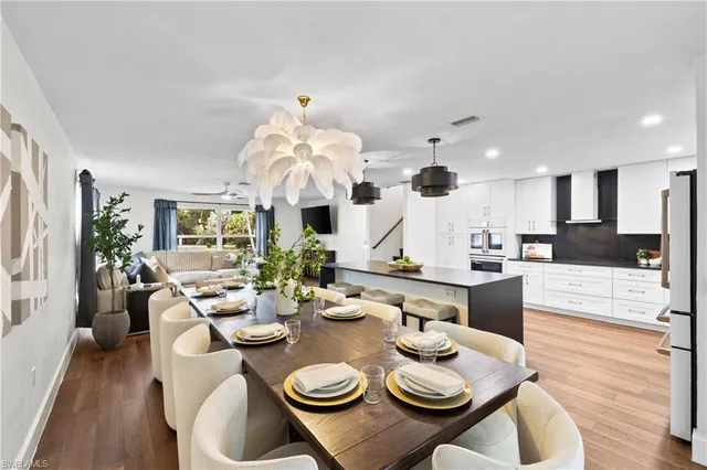 a view of a dining room and livingroom with furniture wooden floor and chandelier