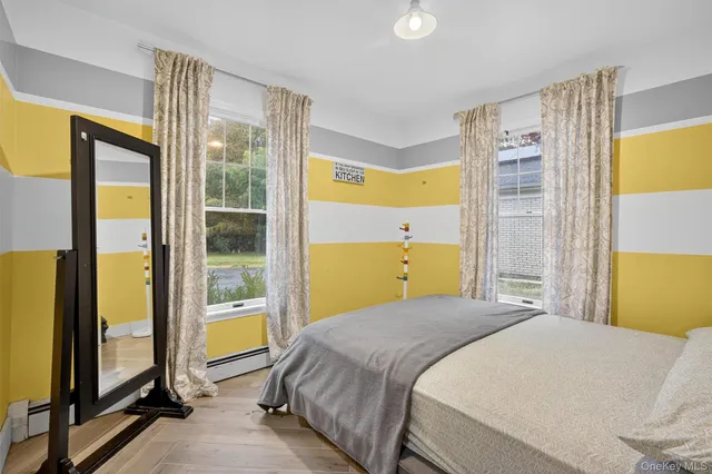 a bedroom with a bed and a dresser next to a window