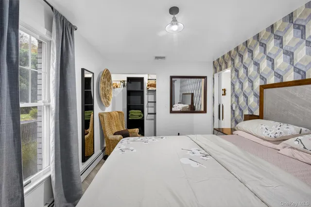 a bedroom with a bed and a large mirror with a wooden floor