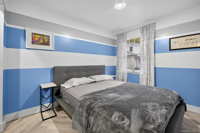 a bedroom with a bed and painting on the wall