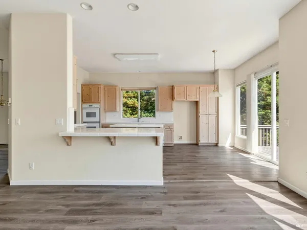 a view of a kitchen with furniture and wooden floor