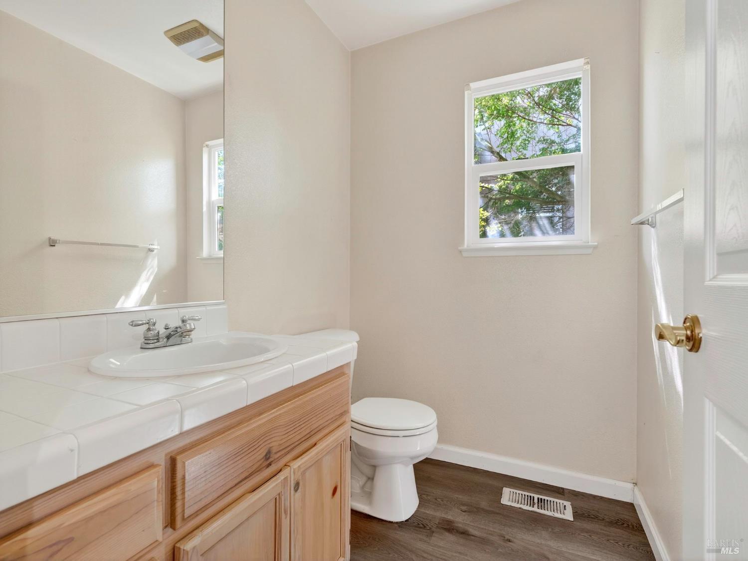 5794 Owl Hill Avenue Santa Rosa, CA 95409 - Photo 22 of 56 a bathroom with a granite countertop sink a toilet and a mirror