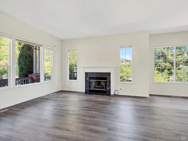 a view of an empty room with wooden floor and stairs