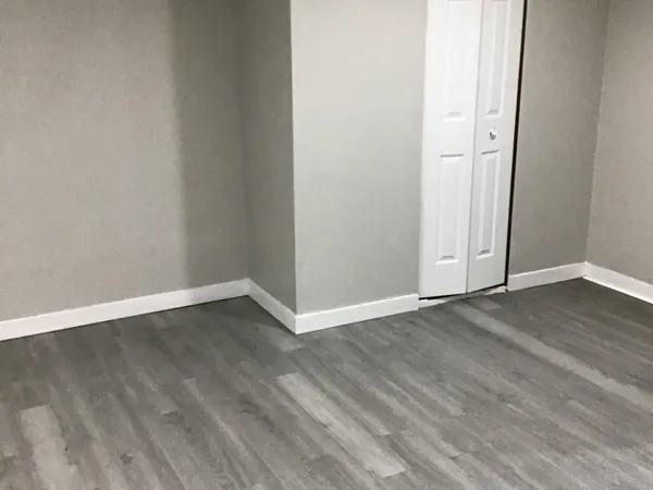a view of an empty room with wooden floor