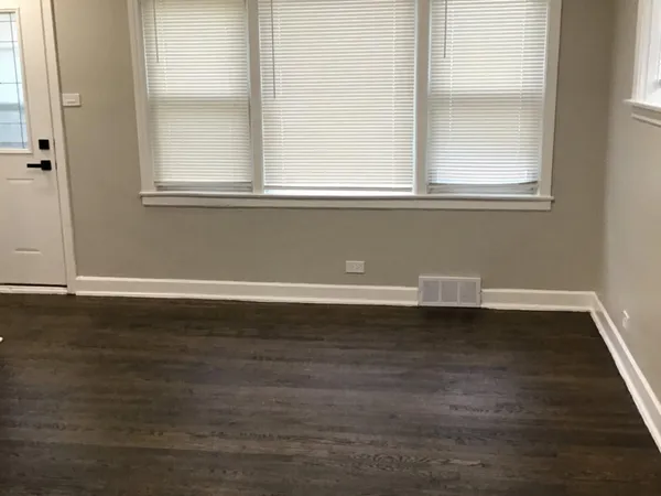 a view of a small space with wooden floor and a window