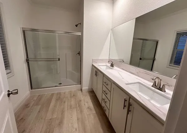 a bathroom with a double vanity sink and mirror