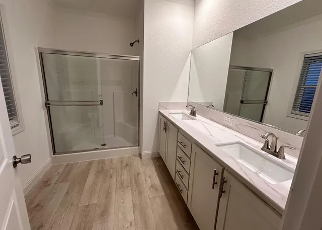 a bathroom with a double vanity sink and mirror