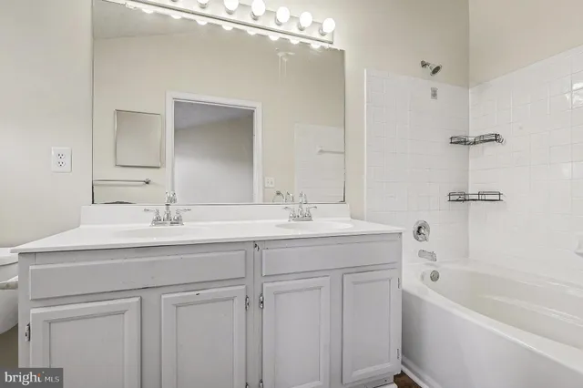 a bathroom with a tub a sink and mirror
