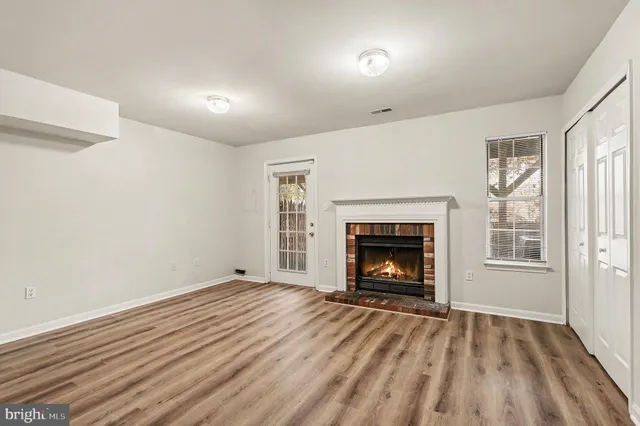 a view of an empty room with a window and fireplace