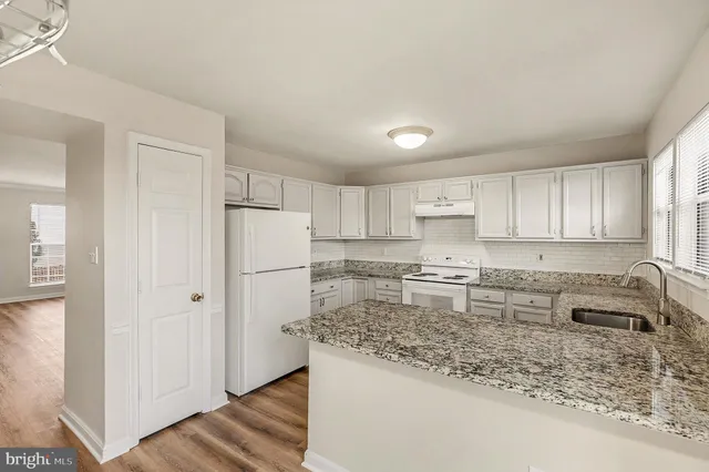 a kitchen with a refrigerator sink and cabinets