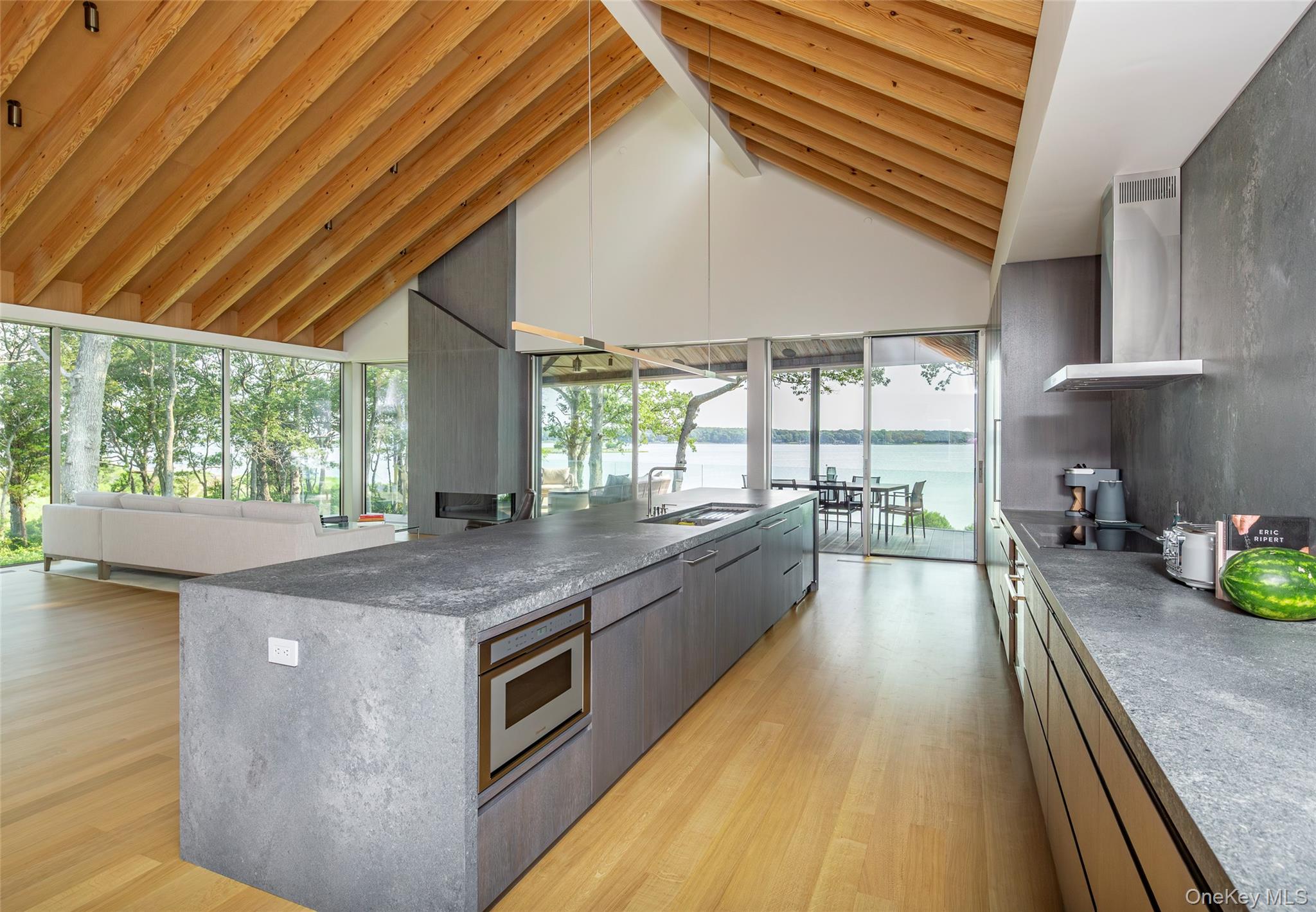 47 L South Ferry Road Shelter Island, NY 11964 - Photo 34 of 35 Kitchen featuring wall chimney range hood, light wood-style floors, a water view, modern cabinets, and open floor plan