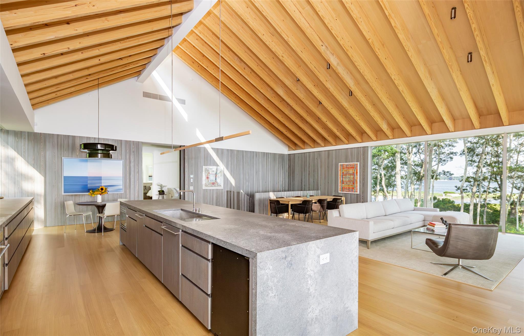 47 L South Ferry Road Shelter Island, NY 11964 - Photo 35 of 35 Kitchen featuring modern cabinets, a center island with sink, open floor plan, high vaulted ceiling, and light wood-style floors