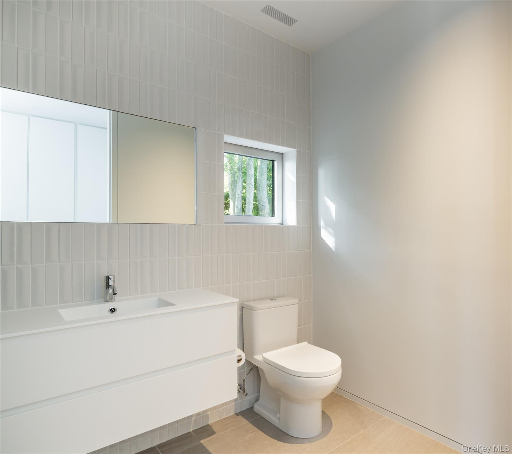 47 L South Ferry Road Shelter Island, NY 11964 - Photo 16 of 35 Bathroom featuring tile walls, vanity, and light tile patterned flooring