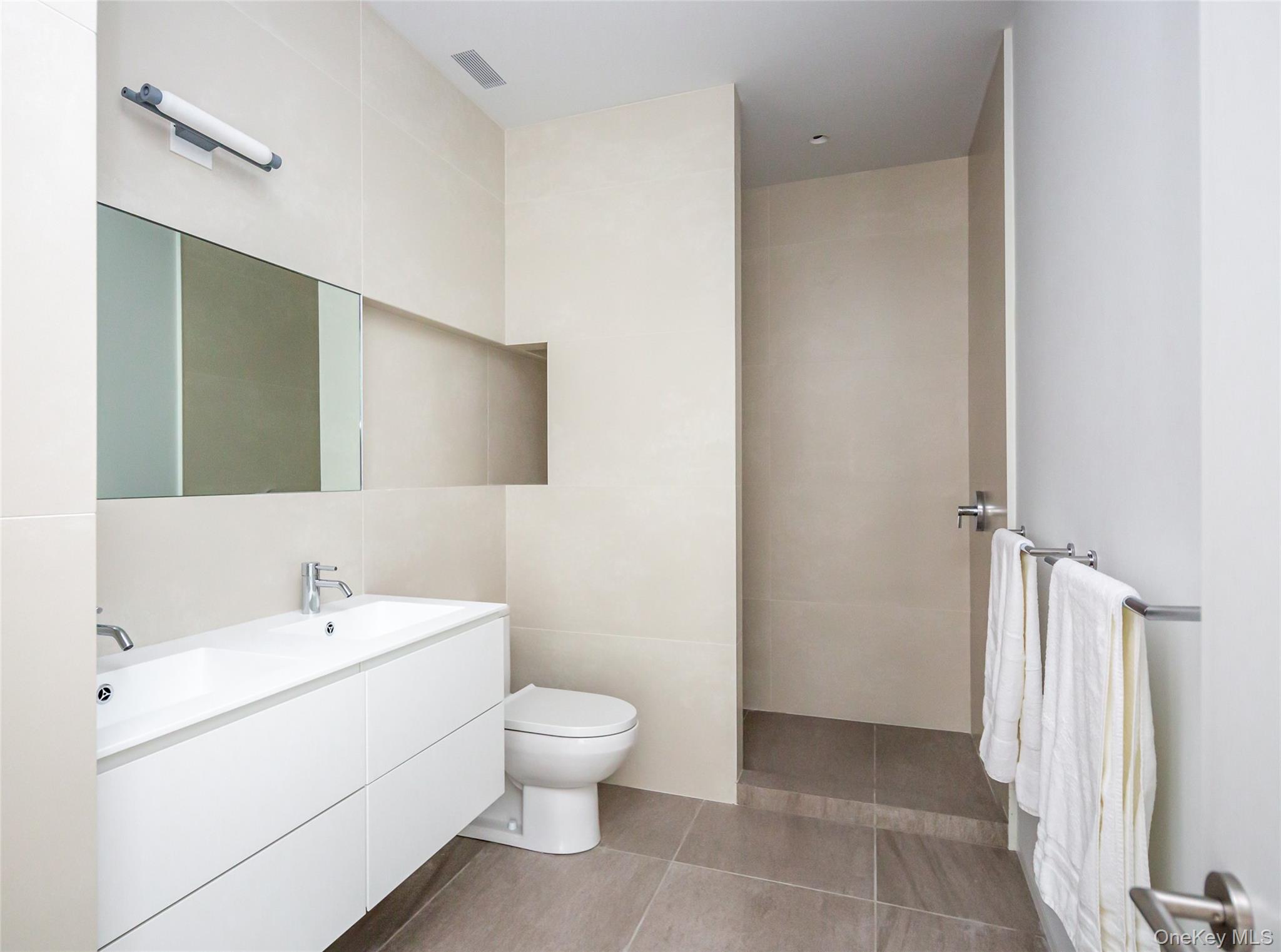 47 L South Ferry Road Shelter Island, NY 11964 - Photo 22 of 35 Bathroom with double vanity, tile walls, and a walk in shower