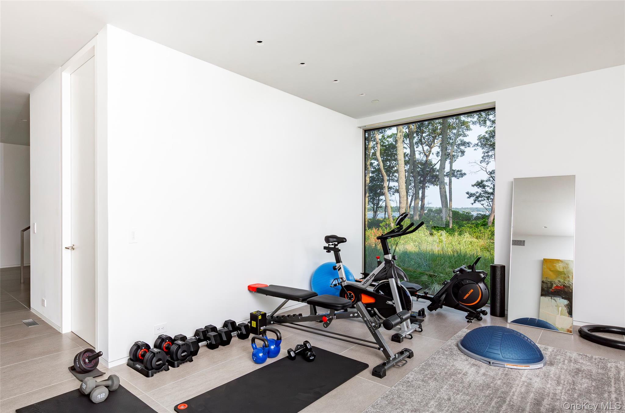 47 L South Ferry Road Shelter Island, NY 11964 - Photo 23 of 35 Workout area with a wall of windows and light tile patterned flooring