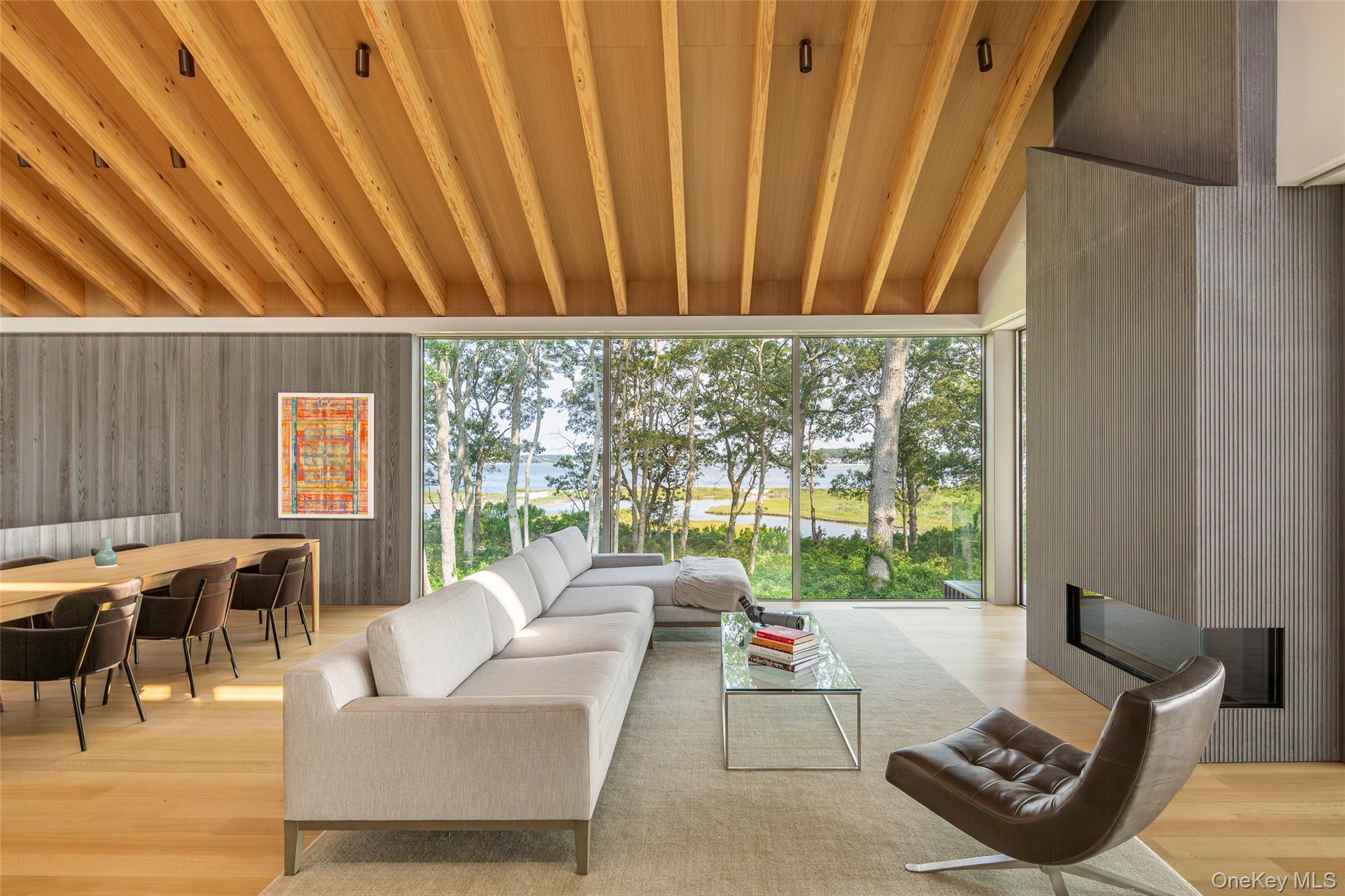 47 L South Ferry Road Shelter Island, NY 11964 - Photo 7 of 35 Living area featuring a large fireplace, a water view, light wood-type flooring, and a wood ceiling with exposed beams