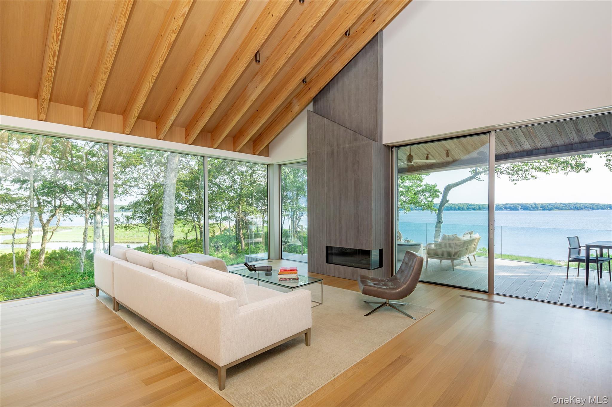 47 L South Ferry Road Shelter Island, NY 11964 - Photo 9 of 35 Sunroom featuring a water view, wood finished floors, high vaulted ceiling, healthy amount of natural light, and wood ceiling
