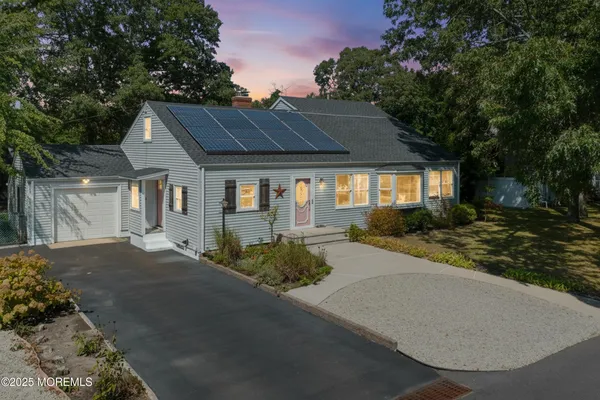 a front view of a house with yard and green space