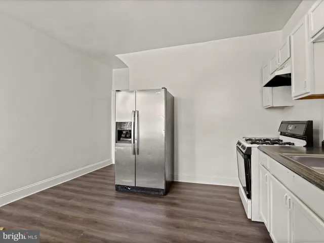 a kitchen with metallic refrigerator and a stove top oven