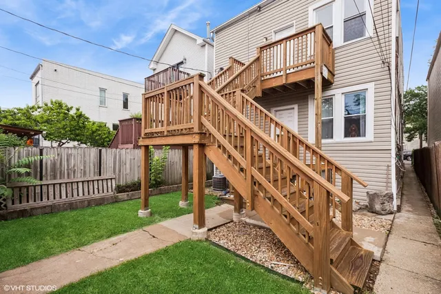 a view of a house with wooden stairs and a small yard