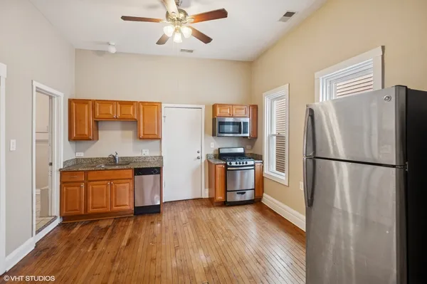 a kitchen with stainless steel appliances a refrigerator a stove top oven a sink and dishwasher