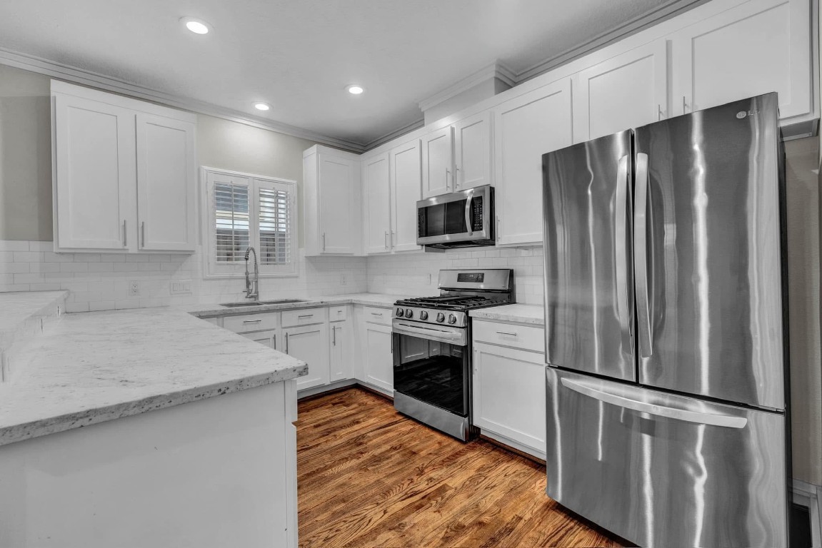 5832 Darling Street, Unit 5 Houston, TX 77007 - Photo 12 of 28 a kitchen with stainless steel appliances a refrigerator sink and microwave