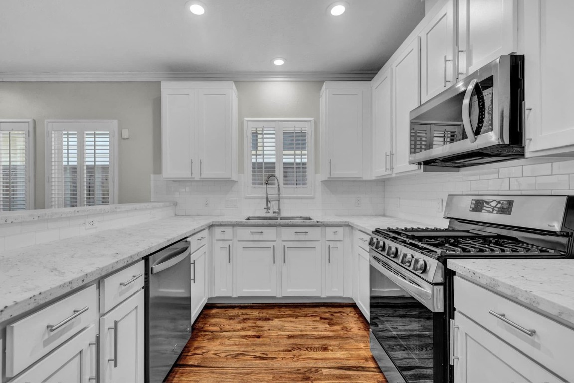 5832 Darling Street, Unit 5 Houston, TX 77007 - Photo 13 of 28 a kitchen with stainless steel appliances granite countertop a stove a sink and a microwave