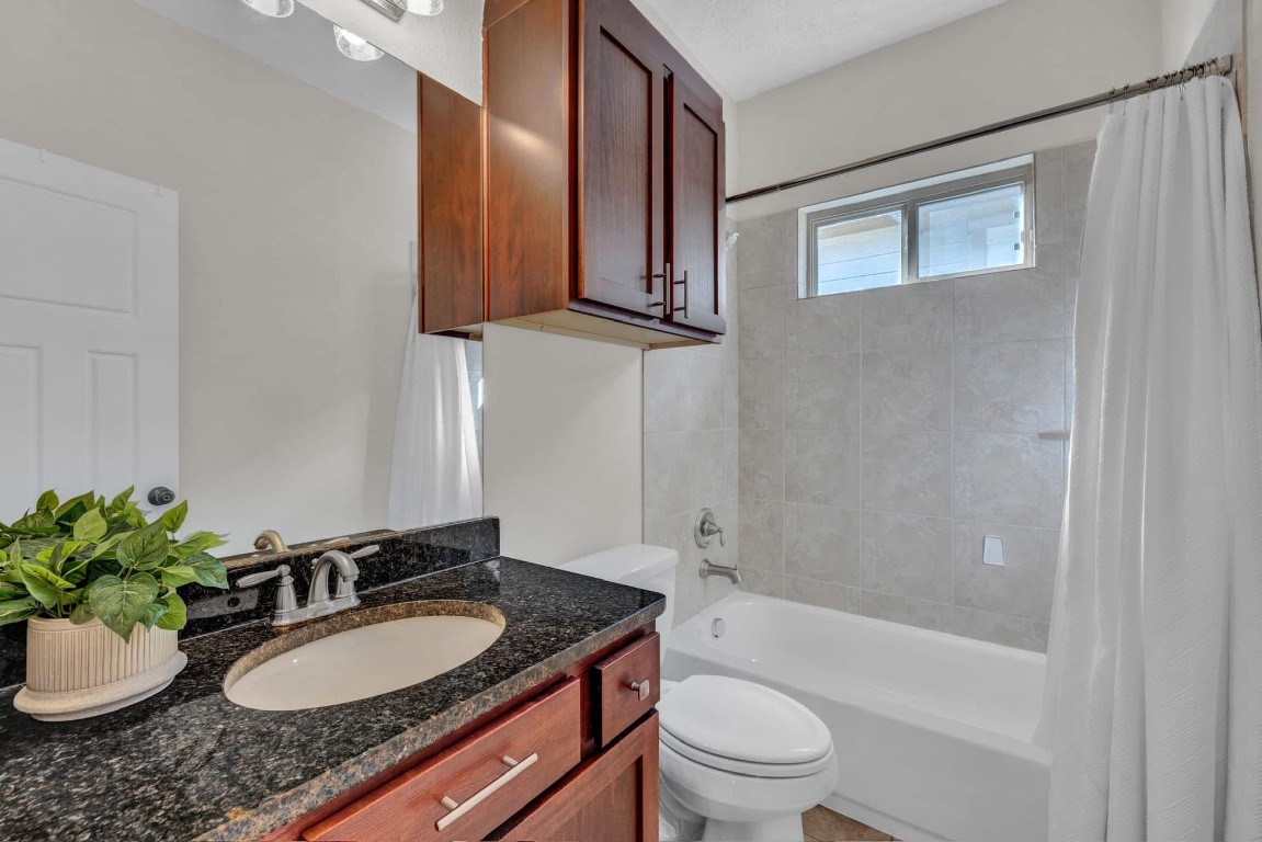 5832 Darling Street, Unit 5 Houston, TX 77007 - Photo 24 of 28 a bathroom with a granite countertop sink a toilet and shower