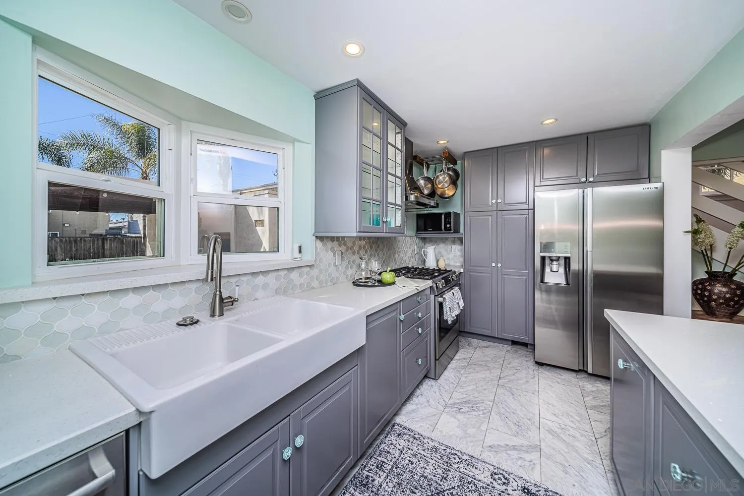 4965 Brighton Avenue Ocean Beach, CA 92107 - Photo 27 of 48 a large white kitchen with a sink and stainless steel appliances