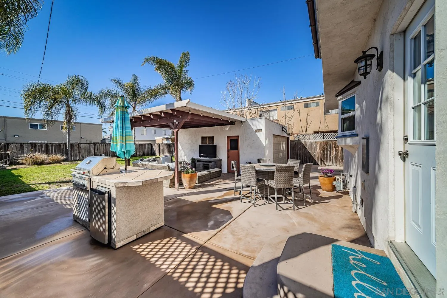 4965 Brighton Avenue Ocean Beach, CA 92107 - Photo 6 of 48 a view of a patio with table and chairs potted plants with wooden floor