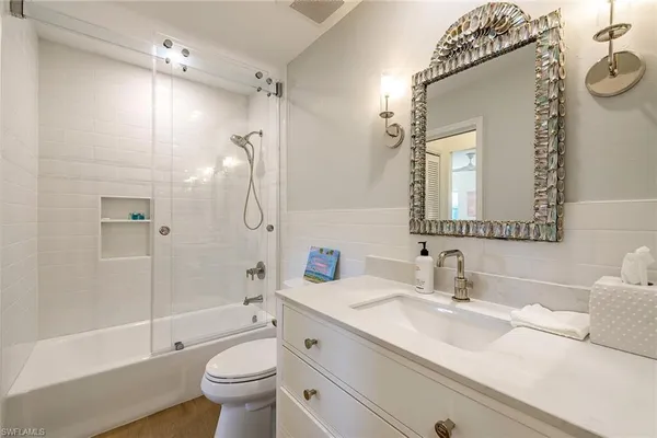 a bathroom with a granite countertop sink a toilet and shower