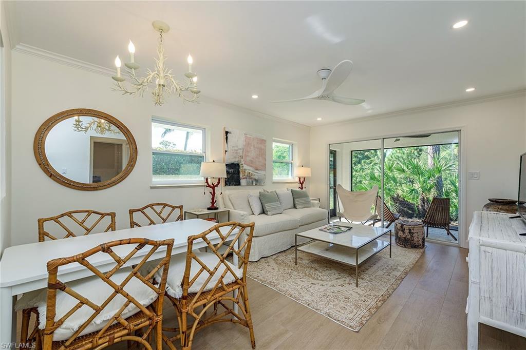 301 Ridge Drive Naples, FL 34108 - Photo 3 of 12 a living room with a couch a dining table a lamp and a large window