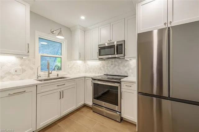 a kitchen with stainless steel appliances a refrigerator sink and microwave