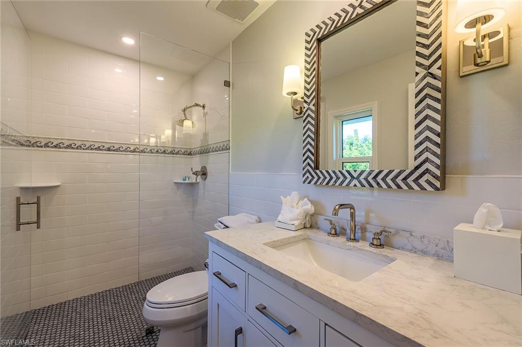 301 Ridge Drive Naples, FL 34108 - Photo 9 of 12 a bathroom with a granite countertop sink mirror vanity and toilet