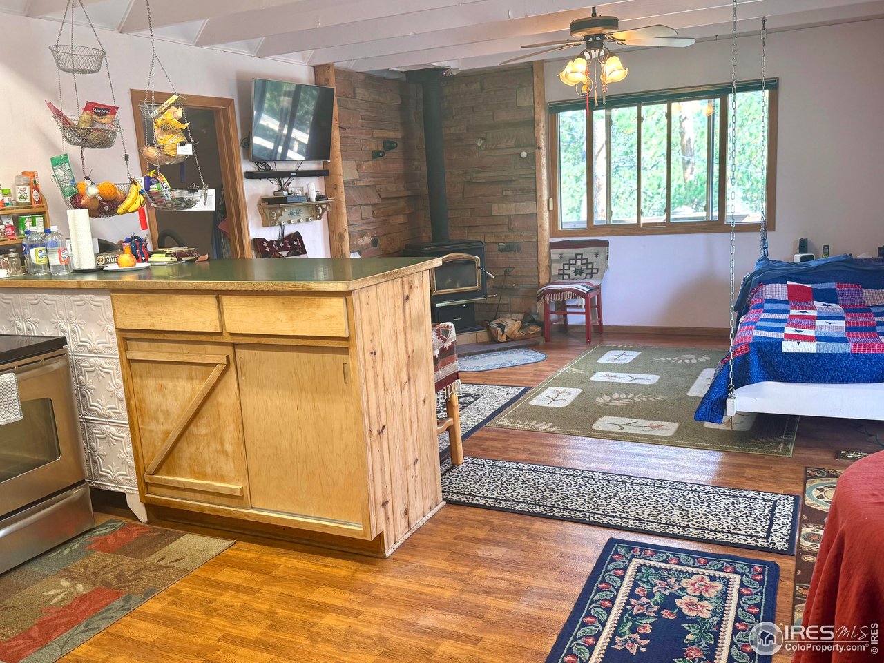 147 Cedar Drive Lyons, CO 80540 - Photo 8 of 37 Kitchen looks into the living room with a removable swinging bed that can be used as a couch too.