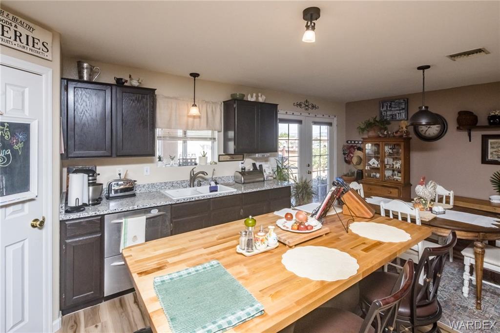 2333 Primavera Loop Fort Mohave, AZ 86426 - Photo 15 of 57 a kitchen with stainless steel appliances granite countertop a sink a stove a dining table and chairs