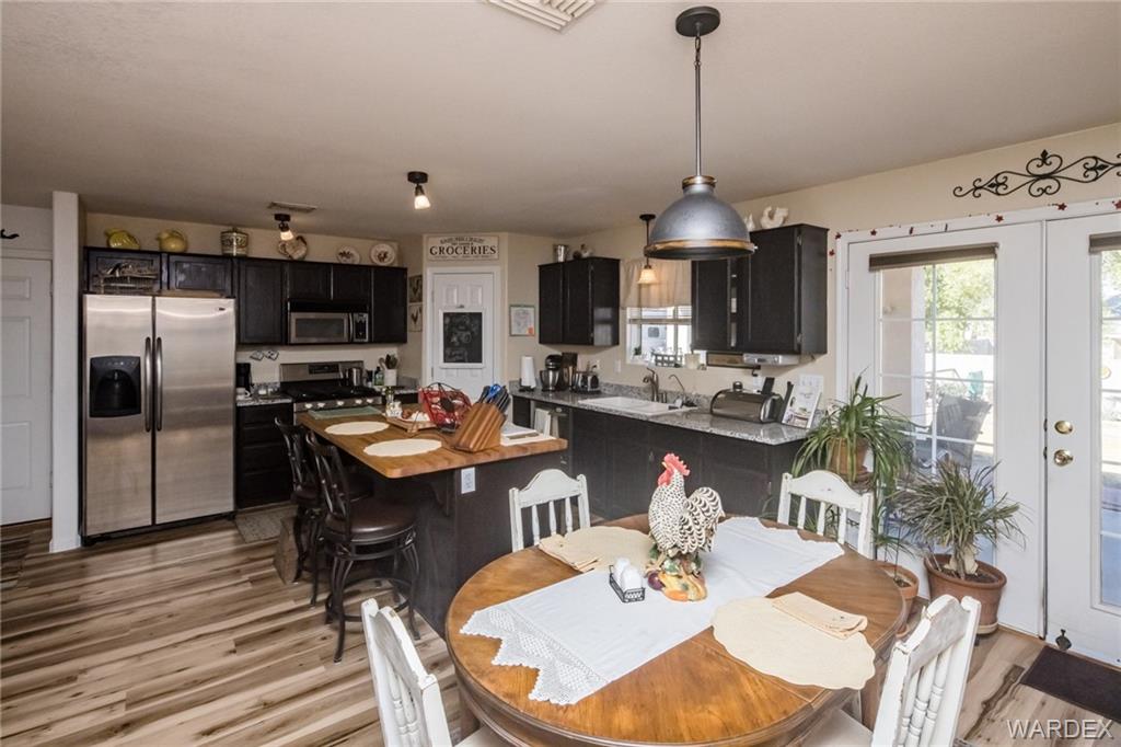 2333 Primavera Loop Fort Mohave, AZ 86426 - Photo 19 of 57 a dining room with stainless steel appliances kitchen island granite countertop a dining table chairs and a refrigerator