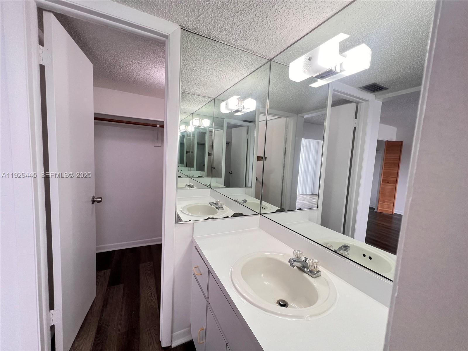 1855 West 60th Street, Unit 430 Hialeah, FL 33012 - Photo 13 of 16 a bathroom with a sink a light fixture and a mirror