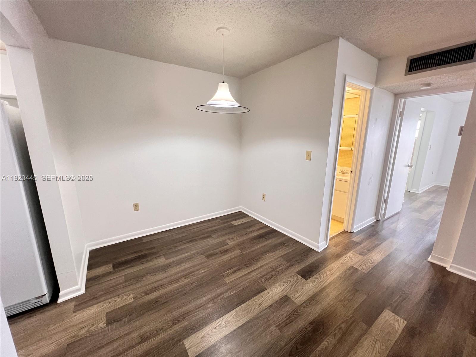 1855 West 60th Street, Unit 430 Hialeah, FL 33012 - Photo 6 of 16 wooden floor in an empty room with a window